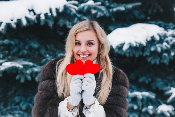 Dia dos Namorados. Mulher sorridente bonita segurando corações vermelhos nas mãos na floresta . — Fotografia de Stock