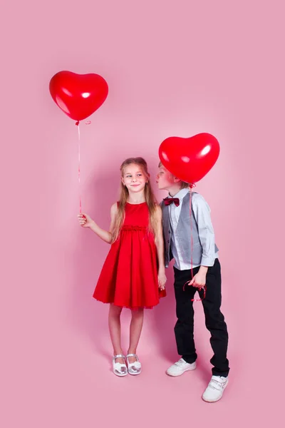 Valentin Nap Kisfiú Csókolgatja Gyönyörű Kislányt Rózsaszín Háttérrel Gyermekek Kezében — Stock Fotó