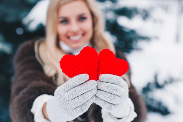 Dois corações de tricô vermelhos em mãos de mulheres. Dia dos namorados — Fotografia de Stock