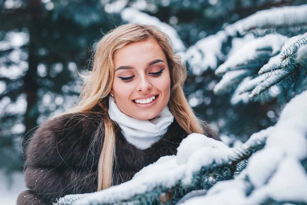 Retrato de invierno de cerca de una joven con el pelo rubio en un parque cubierto de nieve —  Fotos de Stock