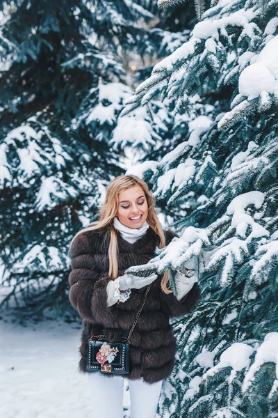 Bela jovem mulher de pé na floresta nevada de inverno. Férias de inverno conceito — Fotografia de Stock