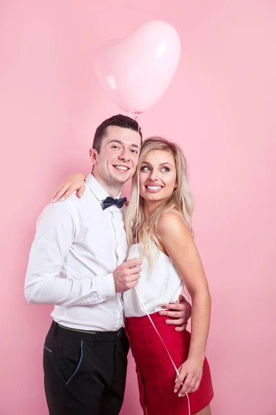 Valentinstag. Schöne romantische Paar mit Herz Ballon auf rosa Hintergrund — Stockfoto