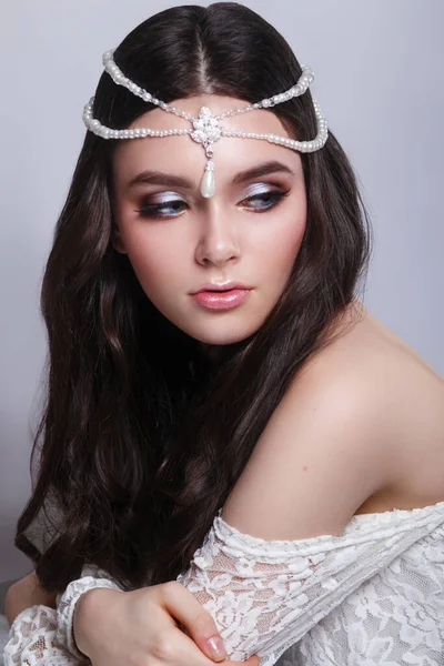 Hermosa mujer con pelo rizado y maquillaje de noche sobre fondo gris. Joyería y Belleza. — Foto de Stock