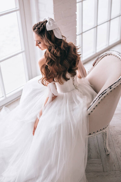 Fashion photo of beautiful bride with dark hair in luxurious wedding dress