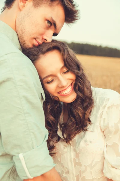 Ungt par i kärlek utomhus. Fantastiska sensuella utomhus porträtt av unga snygga mode par poserar på sommaren i fältet — Stockfoto