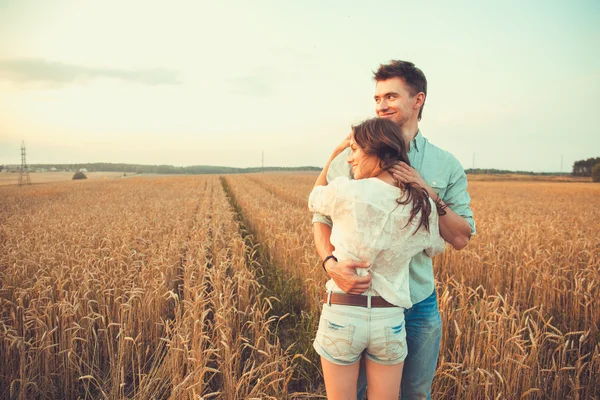 Jovem casal apaixonado ao ar livre.Impressionante retrato ao ar livre sensual de jovem casal de moda elegante posando no verão no campo — Fotografia de Stock