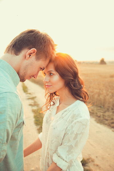 Молодая пара влюблена на открытом воздухе. Потрясающий чувственный открытый портрет молодой стильной моды пара позирует летом в поле
