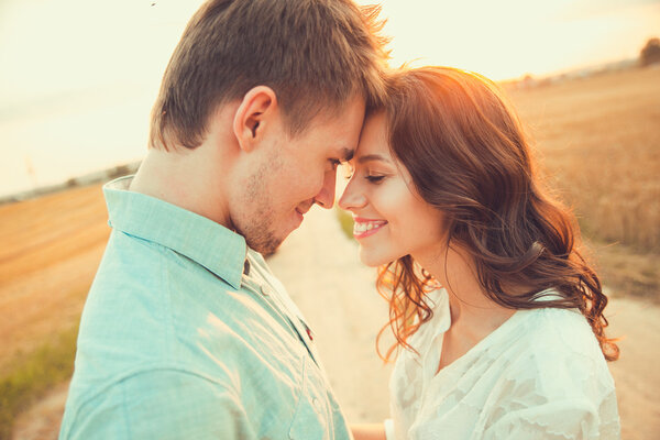 Молодая пара влюблена на открытом воздухе. Потрясающий чувственный открытый портрет молодой стильной моды пара позирует летом в поле
