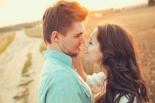 Молодая пара влюблена на открытом воздухе. Потрясающий чувственный открытый портрет молодой стильной моды пара позирует летом в поле
