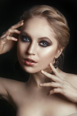 Beauty Woman with Perfect Makeup. Beautiful Professional Holiday Make-up. Glamorous Woman. Fashion model with jewelry, modern natural make up. Black background.