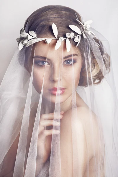 ファッション結婚式の髪型と美しい花嫁-白い背景に。若い豪華な花嫁のクローズアップ肖像画。結婚式。スタジオショット.美しいです花嫁肖像画とともにベール上彼女の顔 — ストック写真