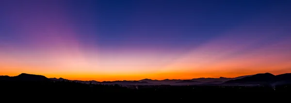 Hermosa puesta de sol sobre un horizonte con siluetas —  Fotos de Stock