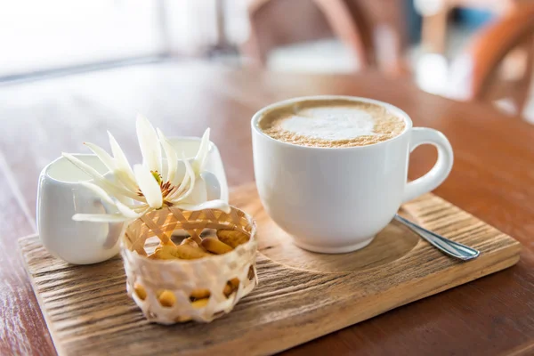 En cappuccino och lite kakor på bordet — Stockfoto