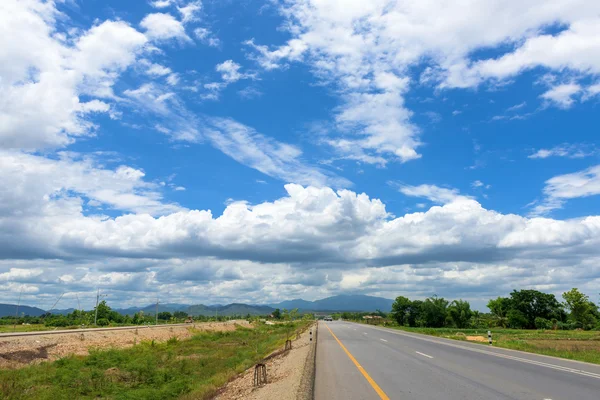Camino de asfalto contra el cielo azul — Foto de Stock