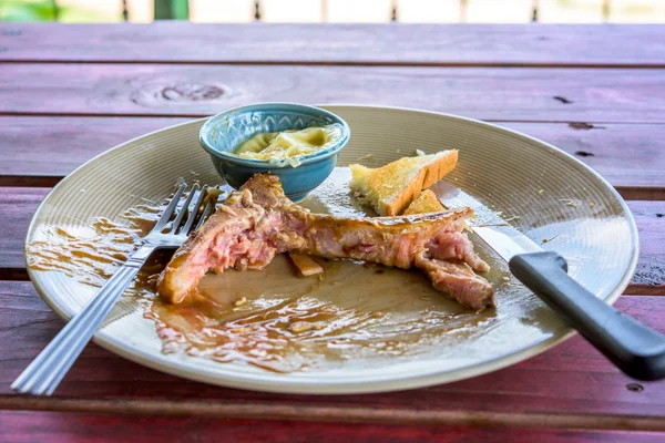 Piatto di bistecca vuoto dopo il cibo sul tavolo Immagine Stock