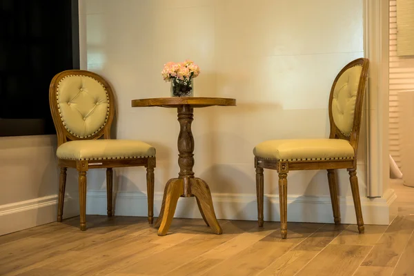 Retro skóry tan fotelem i stolikiem z wnętrza kwiaty — Zdjęcie stockowe