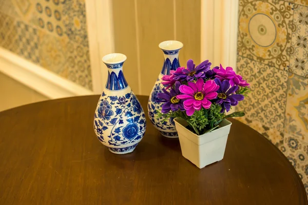 Roze bloemen in een keramische kruik op tafel. — Stockfoto