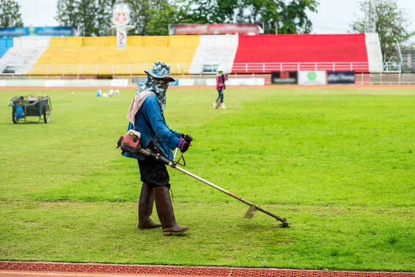 サッカー スタジアムで芝生を刈るワーカー. — ストック写真