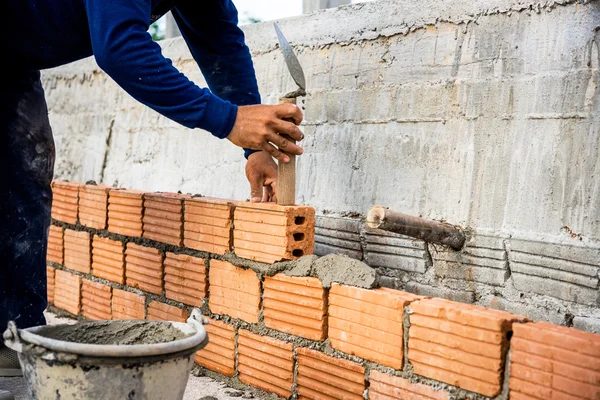 Construtor que coloca tijolos no local . — Fotografia de Stock