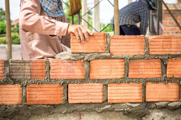 Construtor que coloca tijolos no local . — Fotografia de Stock