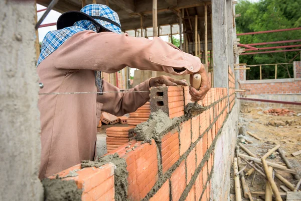 Constructor de ladrillos de colocación en el sitio . — Foto de Stock