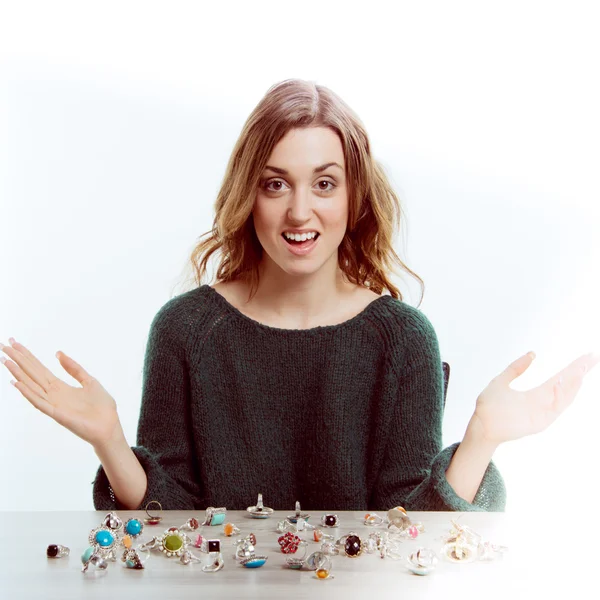 Young woman sitting in front of jewellery — Stock Photo, Image