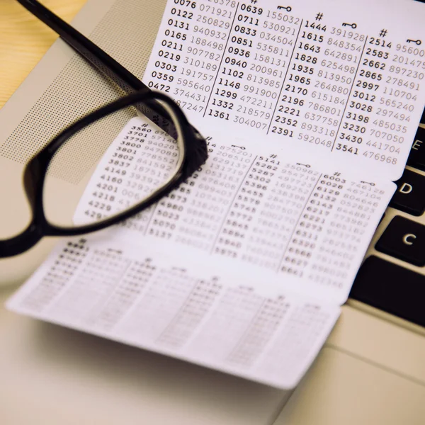 Key card for bank on table with laptop and glasses — Stock Photo, Image