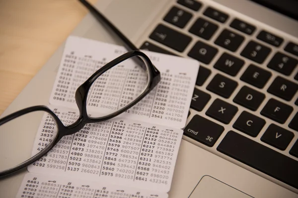 Sleutelkaart voor bank op tafel met laptop en bril Stockafbeelding