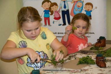Usta sınıfındaki çocuklar taze çiçeklerden el işi yapıyorlar..