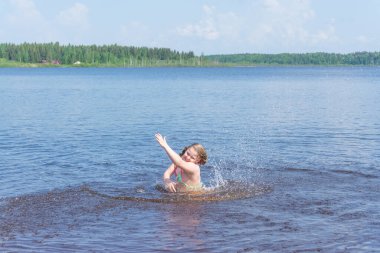 Güneşli bir günde bir kız suda oynuyor.. 