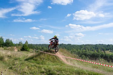 Motokros 2020 'de. Bir motosikletçi engelleri aşarak motosiklet sürer. Torzhok, Tver bölgesi, Rusya. 