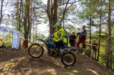 Motokros 2020 'de. Bir motosikletçi engelleri aşarak motosiklet sürer. Torzhok, Tver bölgesi, Rusya. 