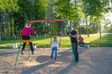 Çocuklar sıcak bir yaz gününde oyun bahçesinde oynarlar..