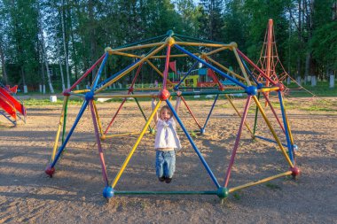 Bir kız, sıcak bir günde yeni bir oyun bahçesinde oynuyor.. 