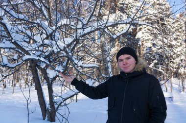 Bir genç kışın karla kaplı bir ormanda yürür ve güzel manzaraya hayran kalır.. 