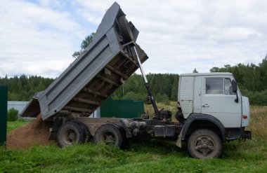 KAMAZ arabası konaklama yerinin bölgesine kum boşaltıyor.. 