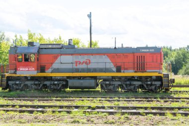 Rus Demiryolları. Dizel lokomotif tren istasyonunun yanındaki raylarda duruyor..
