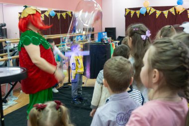 Bir hayır kurumunun doğum gününe adanmış bir hayır etkinliği. Animatörler çocuklara sabun köpüğü gösterisi gösteriyor. 