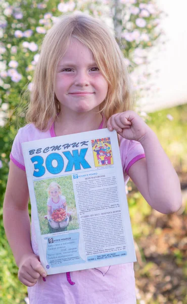 Ein Kleines Mädchen Hält Ein Magazin Mit Ihrem Foto Auf — Stockfoto