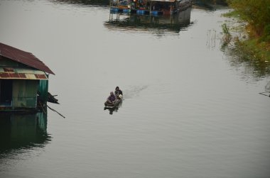 Sal ev ve ahşap tekne Samprasob nehirde kürek insanlar