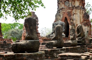 Kırık Buda heykeli ve eski bina