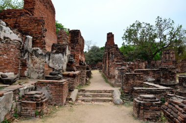 Kırık Buda heykeli ve eski bina