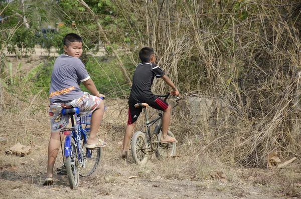 Thai children biking bicycle at Sritasala Cemetery Chinese grave — Stock Photo, Image