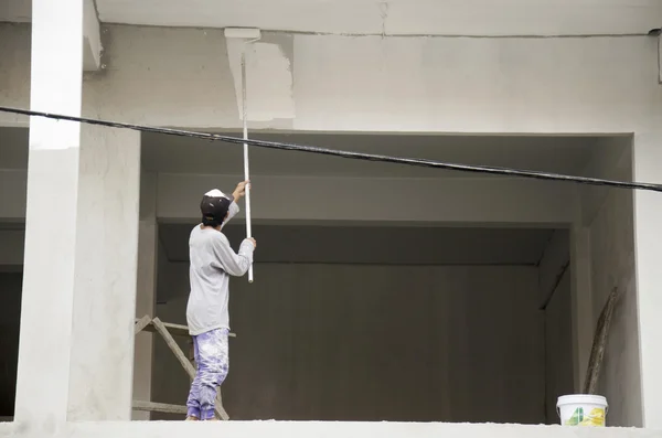 Thajský muž malba bílá barva na budově na staveništi — Stock fotografie
