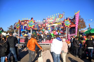 Almanya 'nın Rhineland Palatinate kentinde 30 Ekim 2016 tarihinde Speyer' de düzenlenen karnaval festivali etkinliğinde Almanya vatandaşları ve yabancı turistler alışverişe çıkıp oyuncak lunaparkında oyun oynuyorlar.