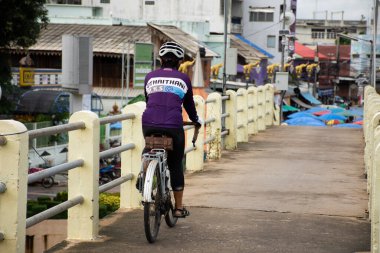 Tayland 'ın Uthai Thani Eyaleti' nde 20 Ekim 2020 tarihinde Uthaithani şehrine ve yerel pazara giden Sakae Krang nehri üzerinde bisiklet süren Taylandlı insanların hayatı