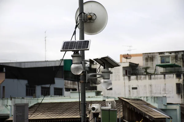 Street pole lamp with solar cell panel and closed circuit television or cctv security camera on post at bridge road at Uthaithani city town in Uthai Thani province Thailand