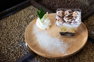 Muz aromalı krema ile doldurulmuş çikolatalı muhallebi keki. Tayland, Udon Thani 'deki kafe ve restoranda ahşap tabakta krema.