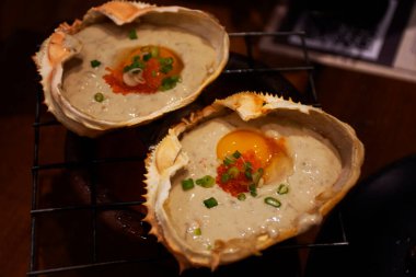 Meşhur Kani Miso ya da Yengeç Ezmesi, tuzlu Japon baharatlı soya fasulyesi. Yengeç kabuğunda bıldırcın yumurtası. Tayland 'ın Udon Thani kentindeki kafe ve restoranda küçük kömür ocağında kızartılıyor.