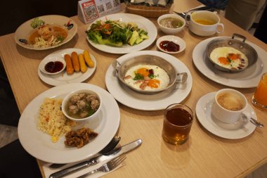 Tayland, Udon Thani 'de 15 Eylül 2020' de Udonthani şehrindeki yerel bir restoranın yemek salonunda yemek yiyen gezginler için sofrada Tayland usulü kahvaltı hazırlamak.